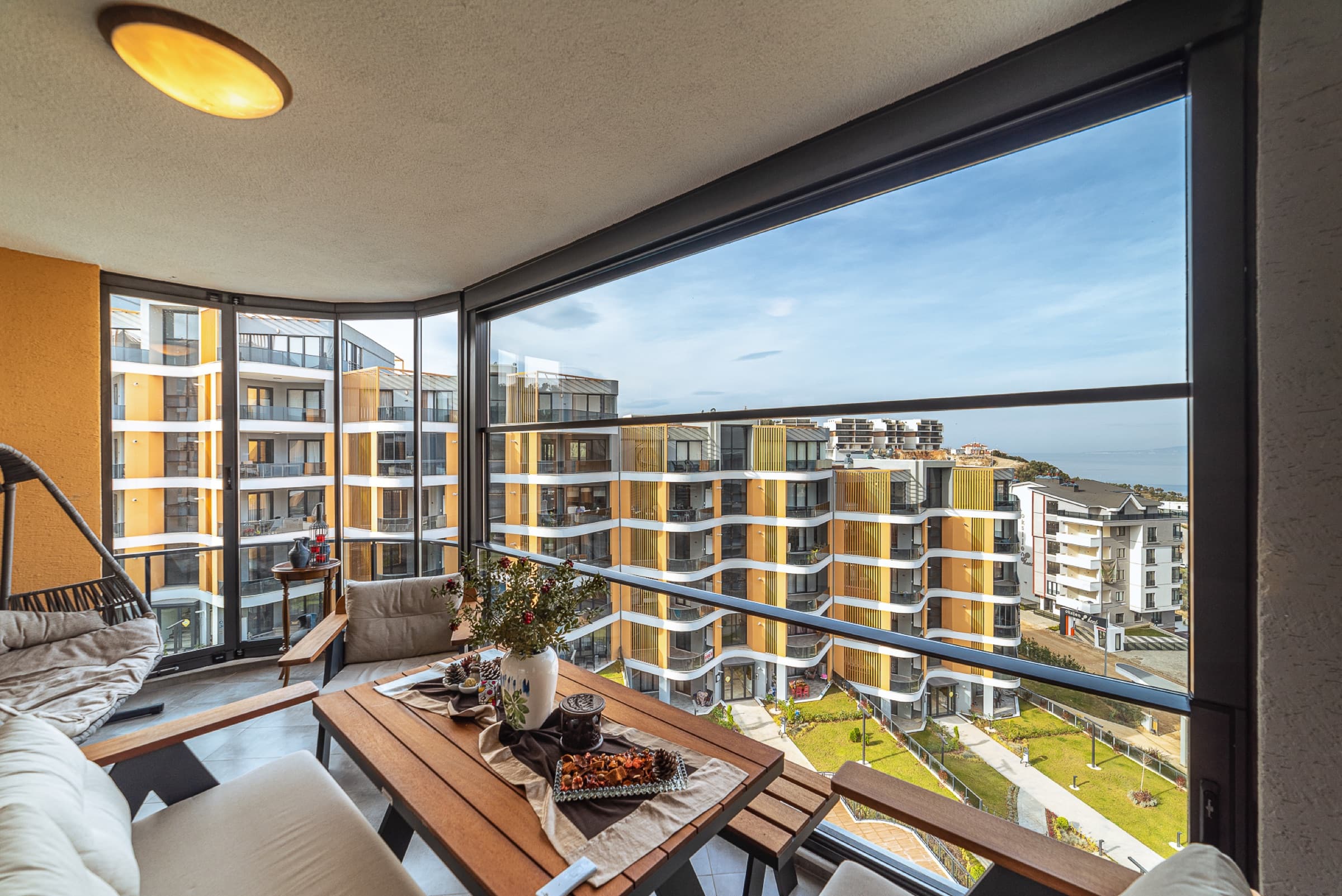 Yemek masası bulunan, şehre bakan cam balkon